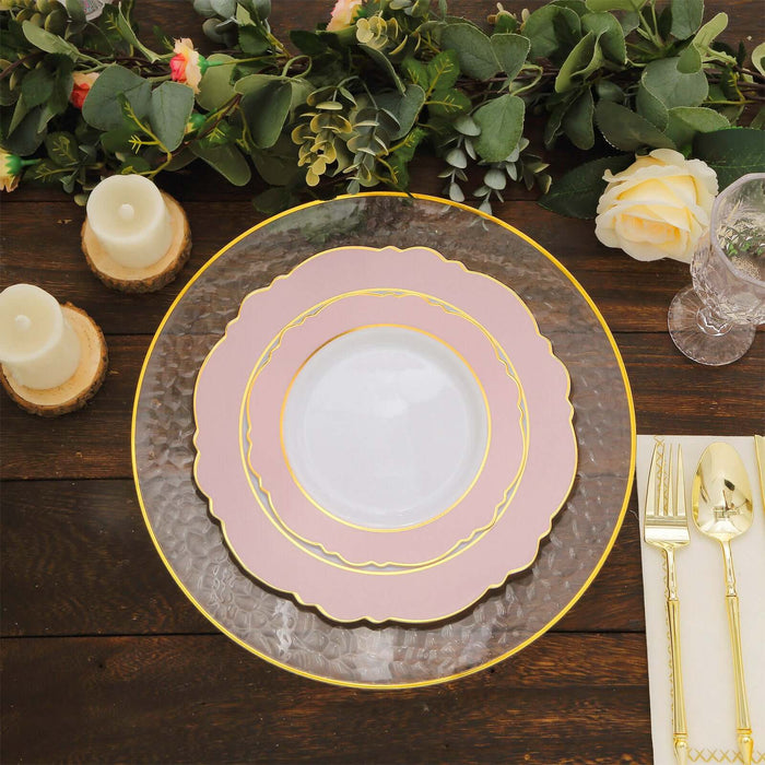 Elegant dinnerware set with layered plates and cutlery on a rustic wooden table.
