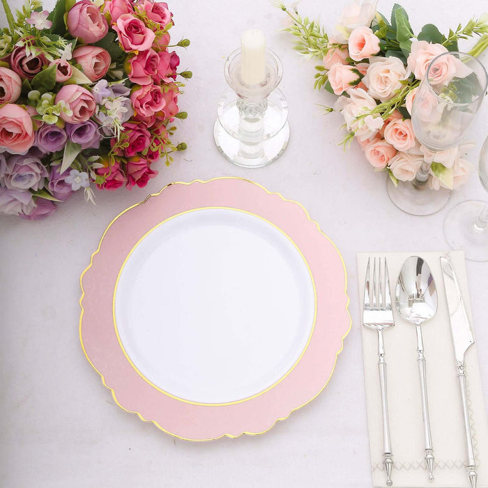 Elegant pink and gold trimmed plate set on a table with flowers and cutlery.