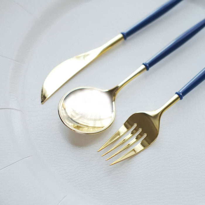 Gold cutlery set with blue handles on a white plate.