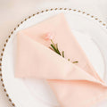 Pink napkin with a flower on a decorative plate.