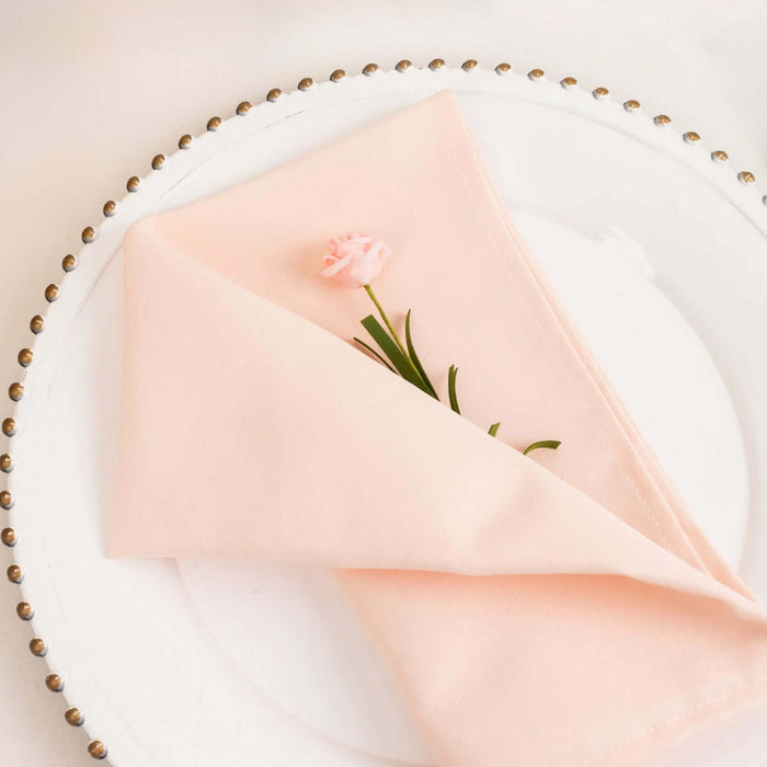 Pink napkin with a flower on a decorative plate.