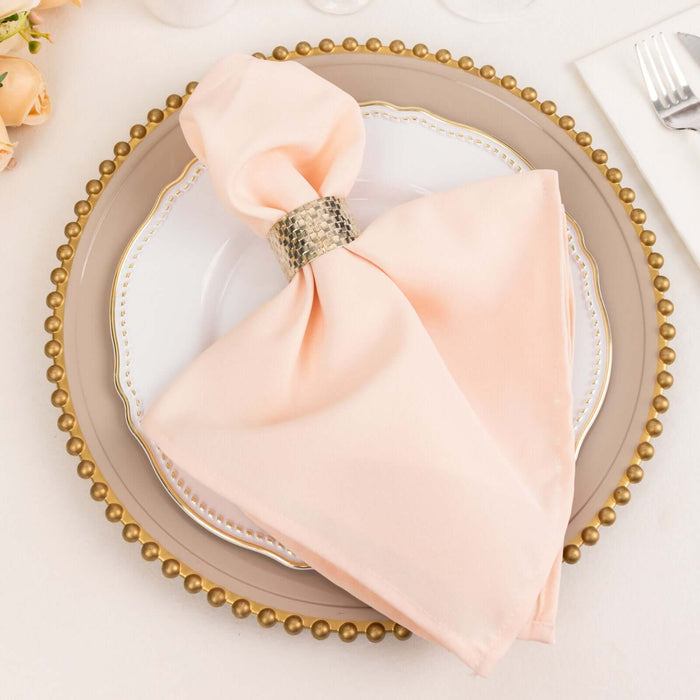 Elegant peach napkin with silver ring on decorative plate.