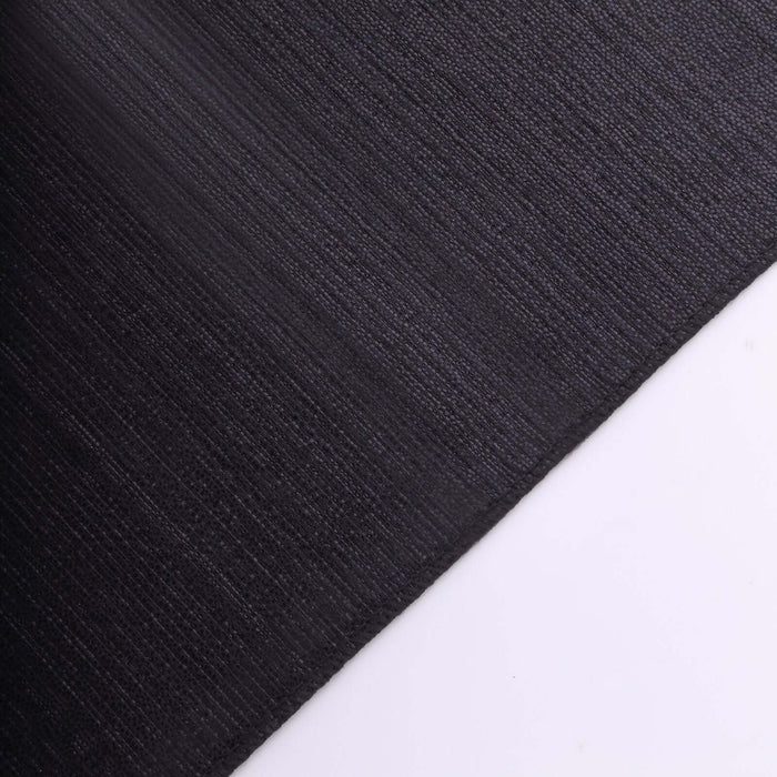Black textured fabric close-up showing intricate weave details.