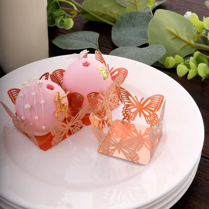 Decorative pink cakes in butterfly-shaped holders on a white plate.