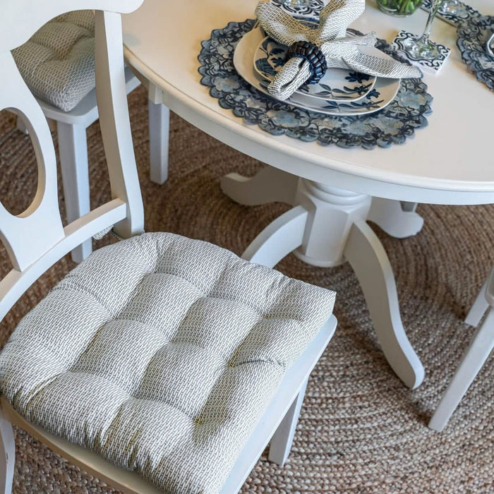 Basketweave slate gray dining chair pad on wooden chair with matching napkin.