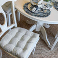Basketweave slate gray dining chair pad on wooden chair with matching napkin.