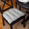 grey upholstered dining chair cushion at black dining room set for dinner party with silver place settings