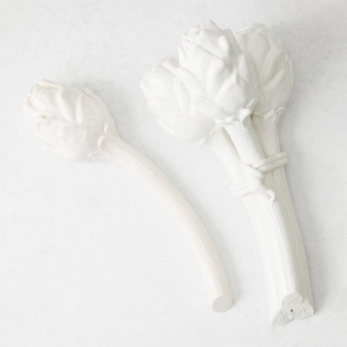 Handmade white glazed ceramic Roman artichoke bunch and single stem on a white background.
