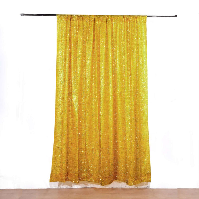 Yellow glitter curtain panel on a black rod against a white backdrop.