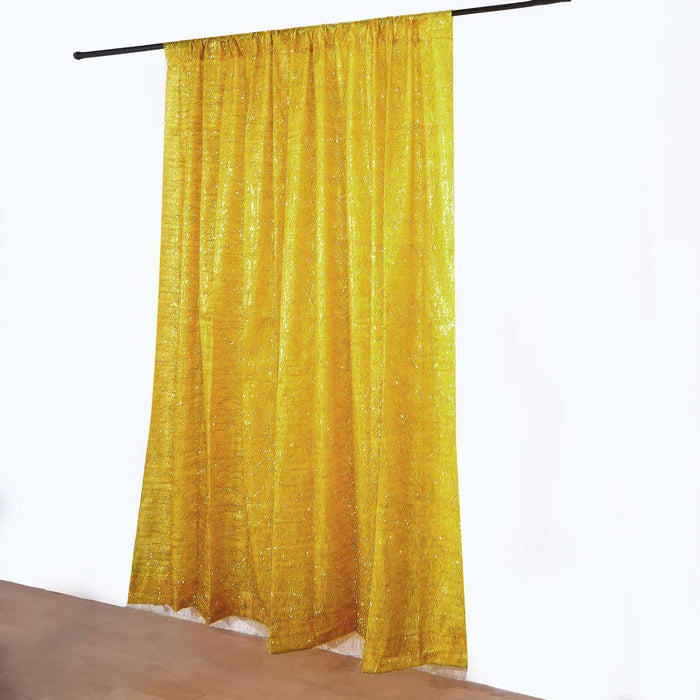 Yellow shimmering curtain hanging from a rod against a white backdrop.