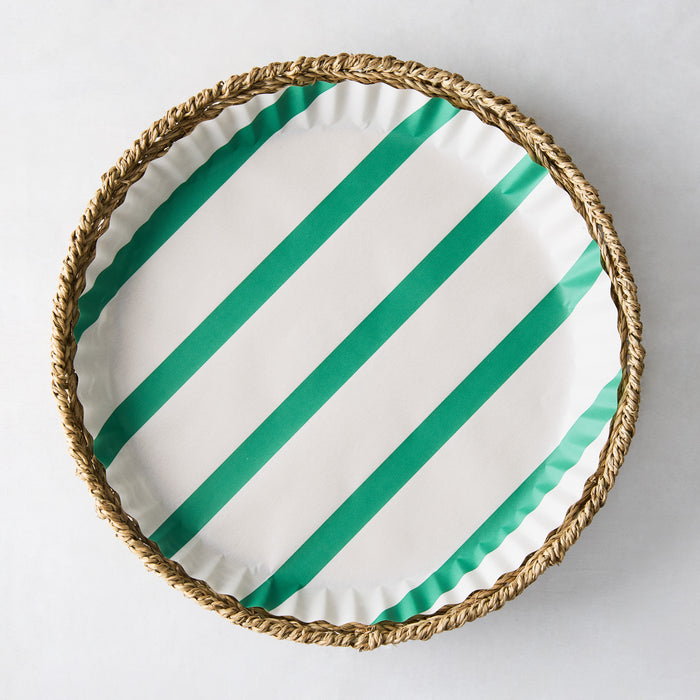 Round white parchment liner with green diagonal stripes in a woven basket.