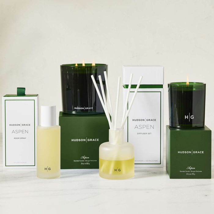 Hudson Grace Aspen diffuser set with candles, room spray, and boxes on a white surface.