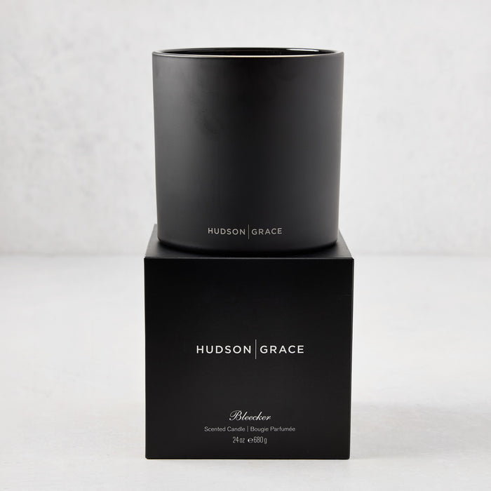 Hudson Grace Bleecker Scented 3-Wick Candle in a matte black glass vessel on its matching black gift box.