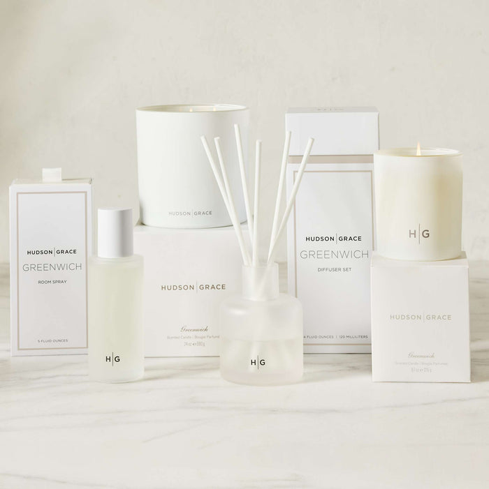 Hudson Grace Greenwich white scented votive, room spray, diffuser, and candles in minimalist packaging.