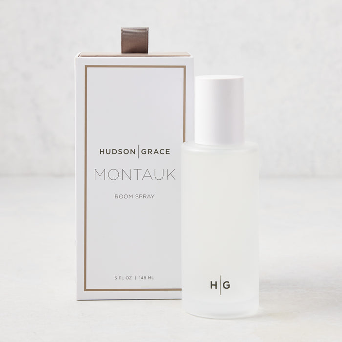 Hudson Grace Montauk 5.08 oz frosted glass room spray bottle with white cap next to its white and gold box.