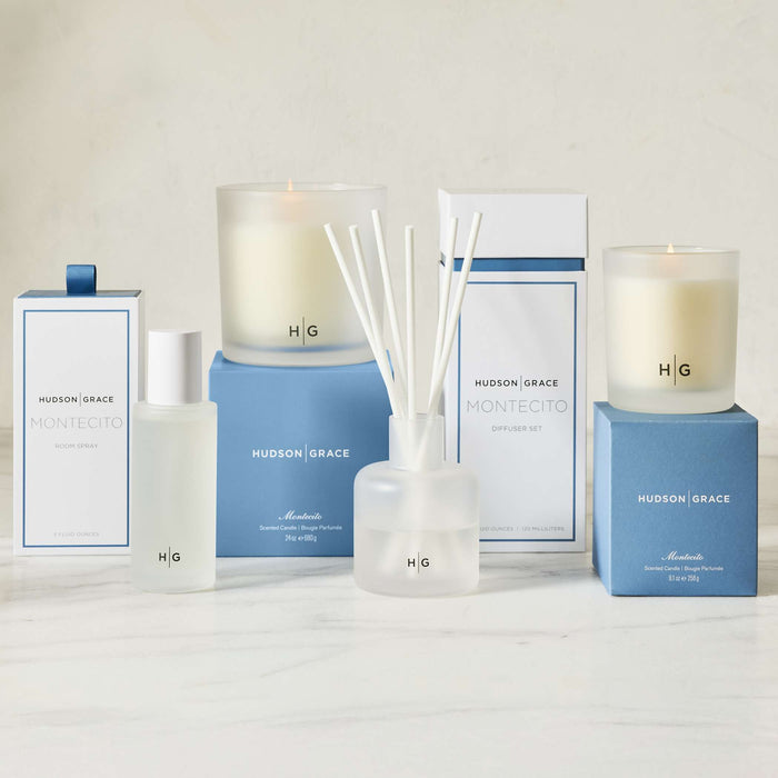 Hudson Grace Montecito scented room spray, candles, and reed diffuser set in white and blue packaging.