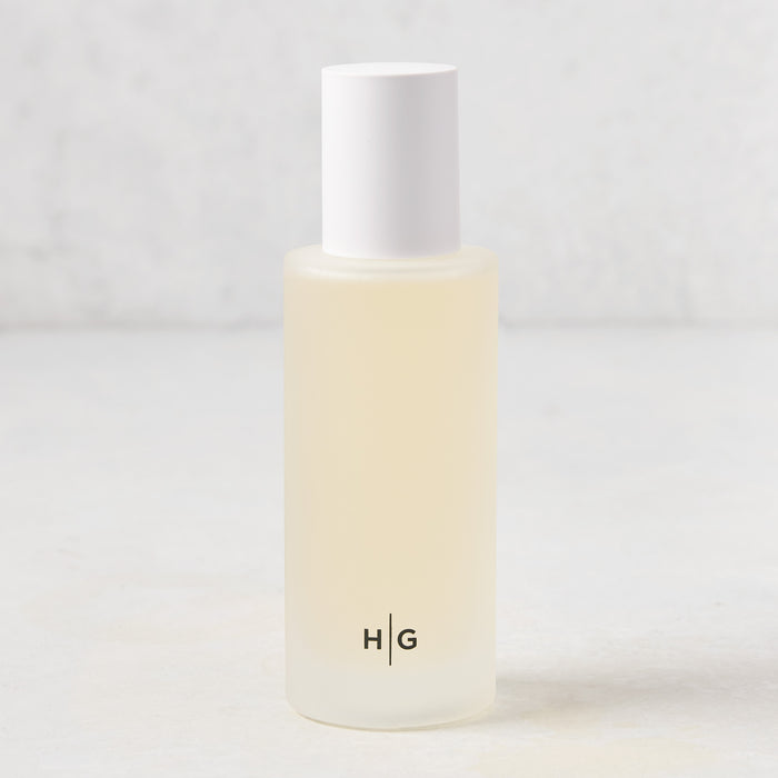 Hudson Grace Montecito scented room spray in a frosted glass bottle with white cap and "HG" logo.