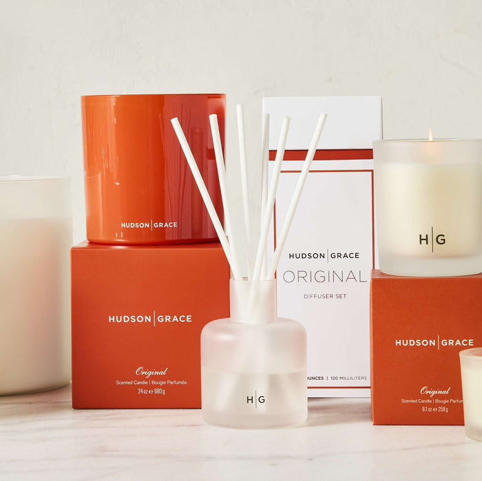 Hudson Grace Original scented candles and diffuser set in orange and frosted glass vessels.