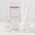 Hudson Grace Palm Beach reed diffuser set with frosted glass vessel, white reeds, and oil bottle.