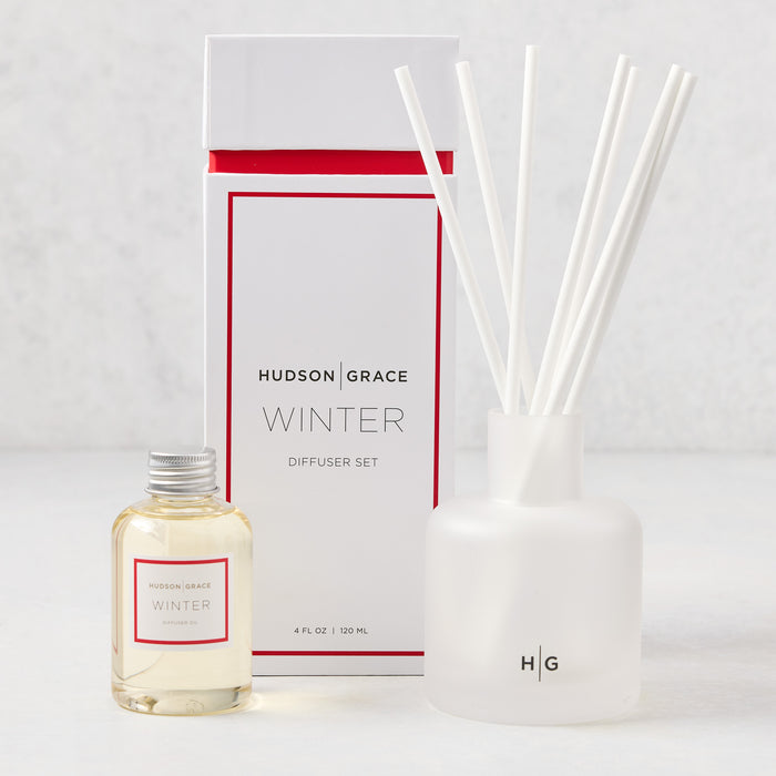 Hudson Grace Winter Scented Reed Diffuser set: frosted white glass vessel, 6 white reeds, and oil bottle.
