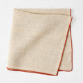 22-inch square khaki linen napkin with a contrasting brick red embroidered tipped stitch edge.