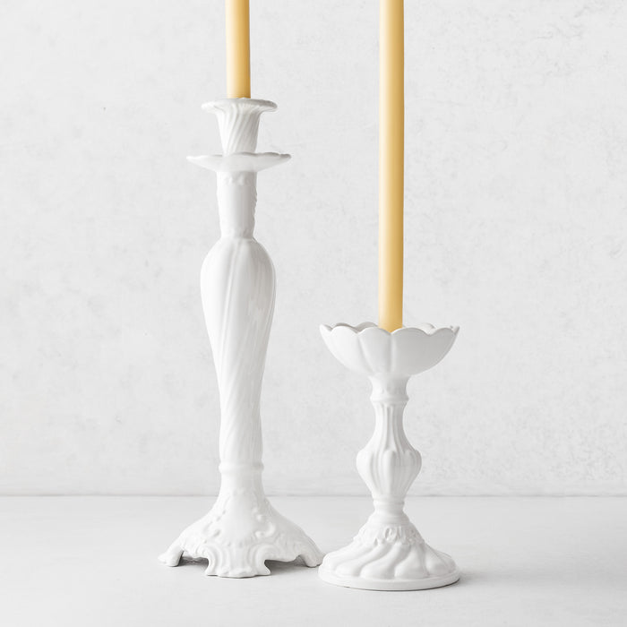 Large and small white ceramic Tosca candlesticks with elegant Italian-inspired designs and taper candles.