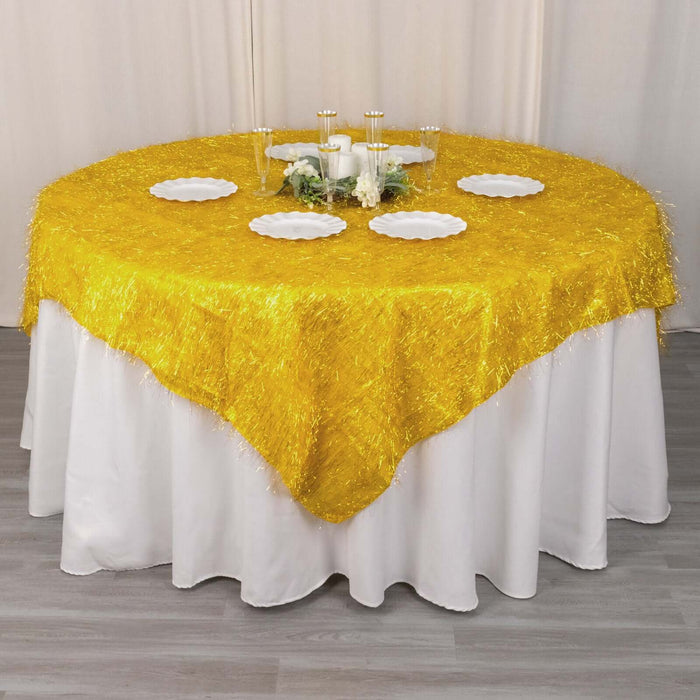 Yellow fringed tablecloth on a round table with white plates and decor.
