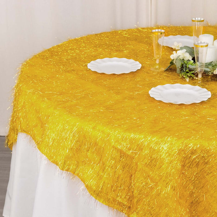 Gold shimmer tablecloth with decorative plates and floral centerpiece.