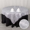 Silver tinsel table overlay with black tablecloth and decorative candles.