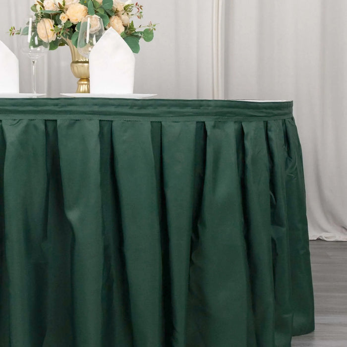 Green table skirt with pleats, elegantly styled for event decor.
