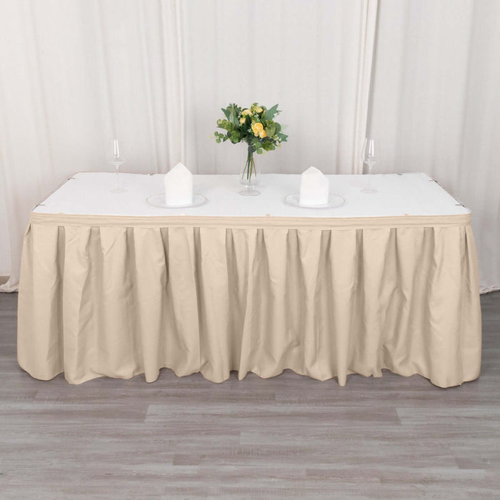Beige tablecloth draped over a long table with floral centerpiece and plates.