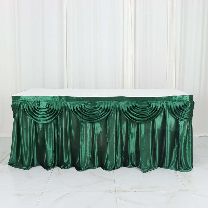 Green satin table skirt with elegant draping for events and celebrations.