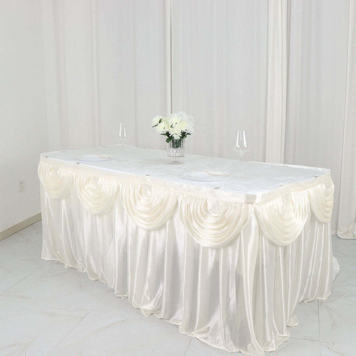 Elegant white table with silky draping and floral centerpiece.