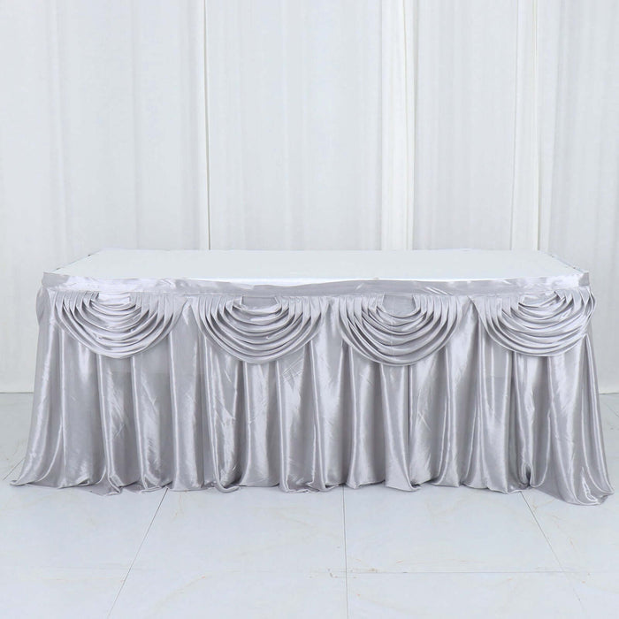 Silver satin tablecloth with elegant draping design.