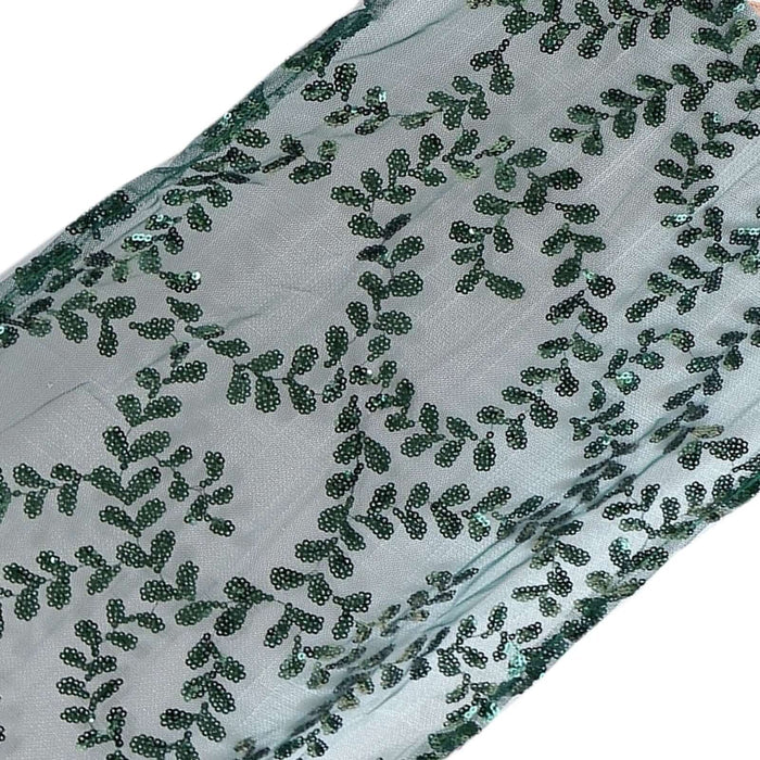 Green sequin fabric with leaf pattern on a light background. #whtbkgd