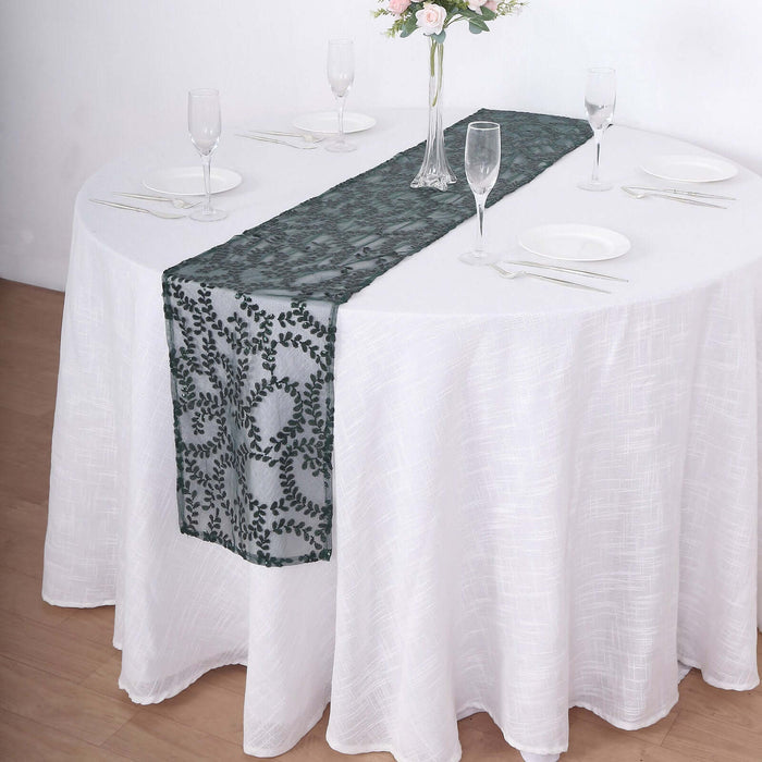 Green floral table runner on a white table setting with glassware and plates.