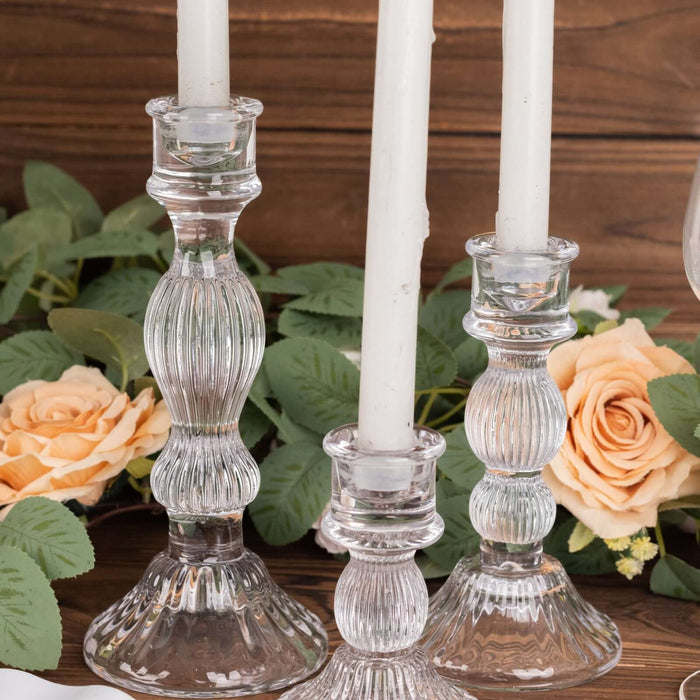 Elegant crystal candle holders with white candles and floral accents.