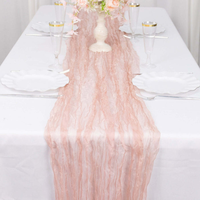 Pink textured table runner on a white table setting with elegant dinnerware.
