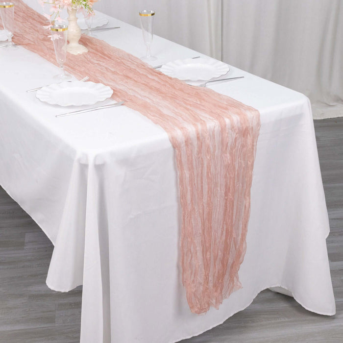Pink table runner on a white tablecloth for elegant dining setup.