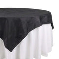 Black tablecloth with textured design, elegantly draped over a white table.