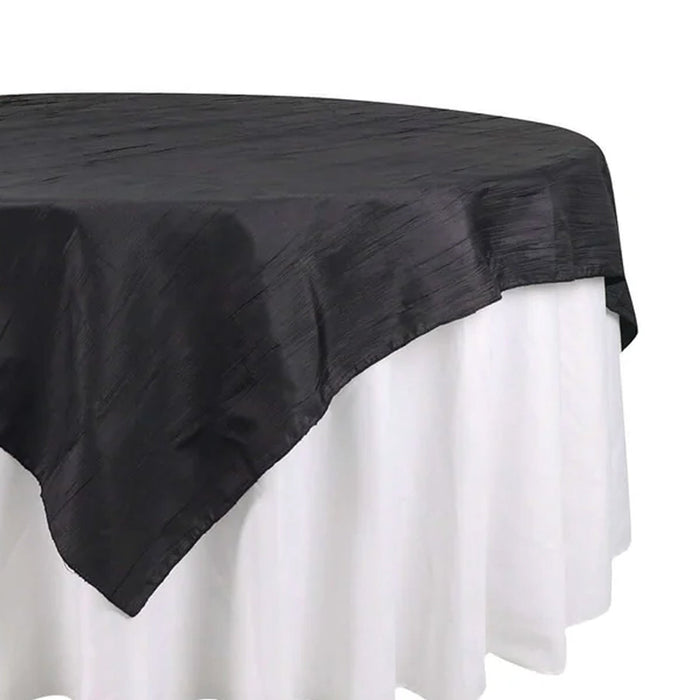 Black tablecloth with textured design, elegantly draped over a white table.