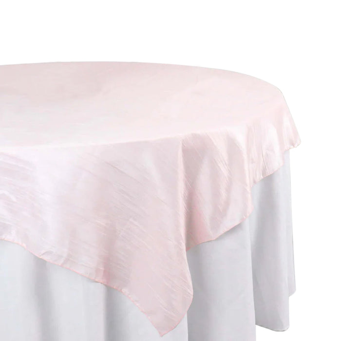 Pink round tablecloth on a white table.