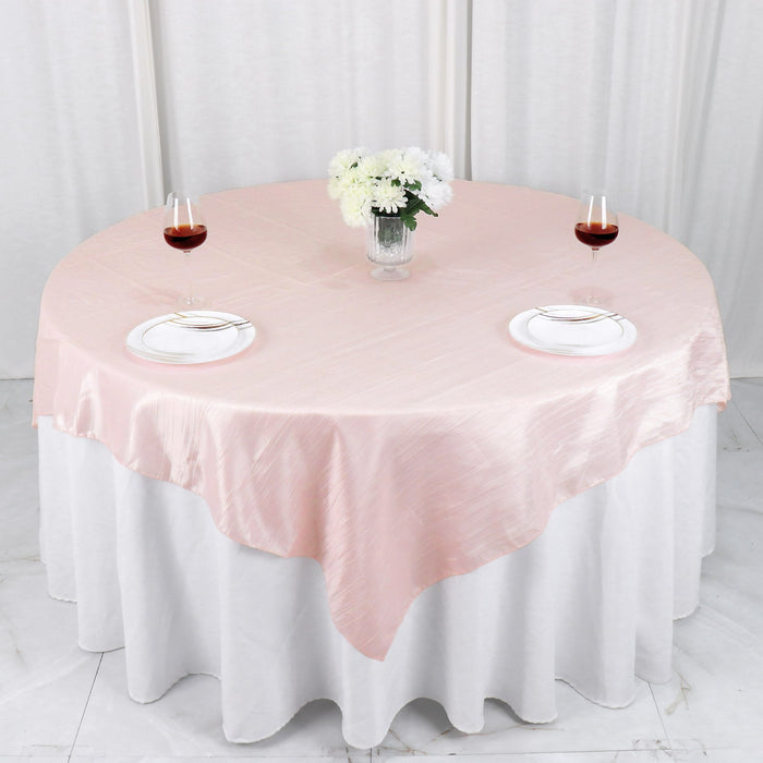 Pink round tablecloth draped elegantly on a dining table with wine glasses.