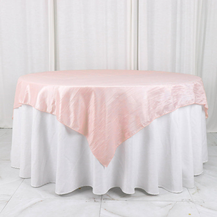 Round pink satin tablecloth draped over a white table.