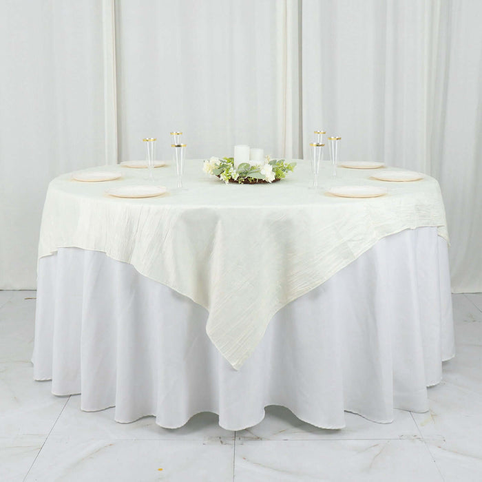 Elegant round table set with white tablecloth and floral centerpiece.