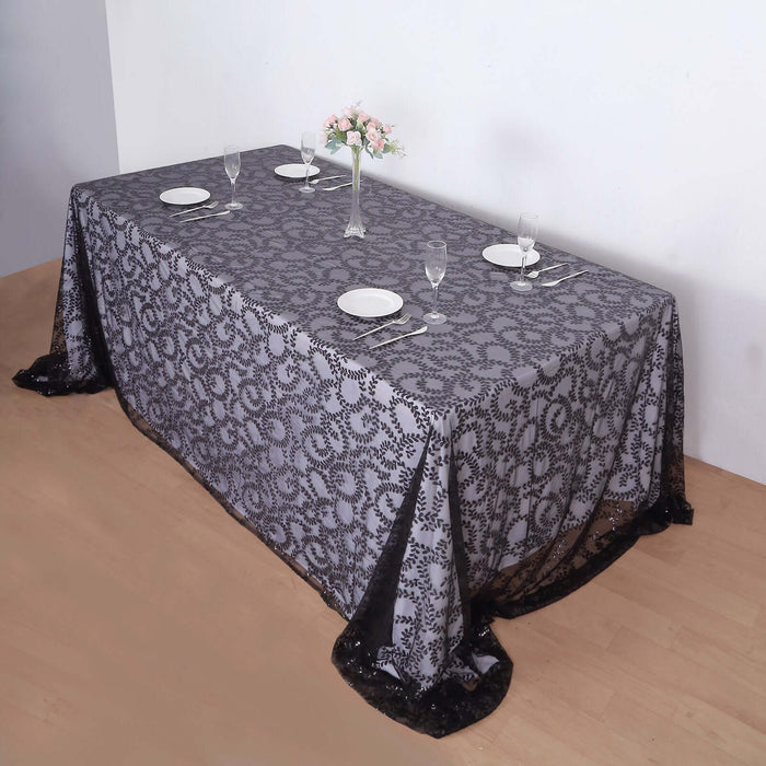 Elegant gray lace tablecloth draped over a dining table with place settings.