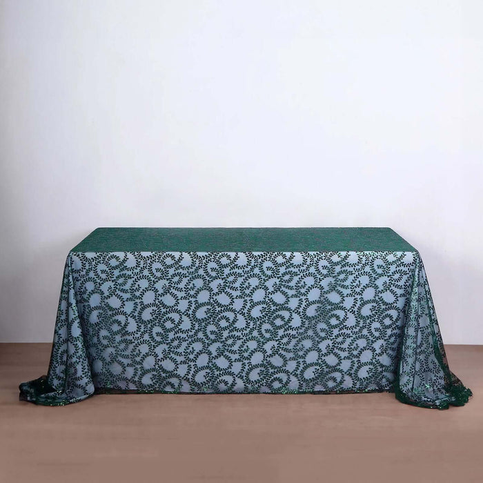 Green patterned tablecloth on a wooden table against a neutral backdrop.