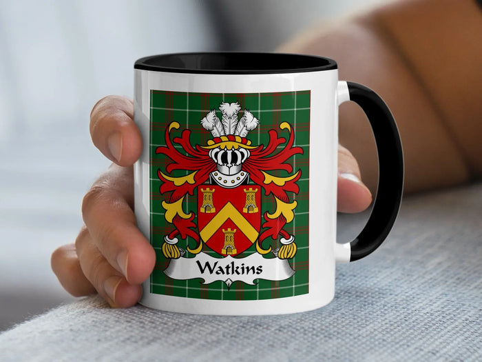 Black-accent Watkins mug held in a hand, showing a red shield with a gold chevron and towers.