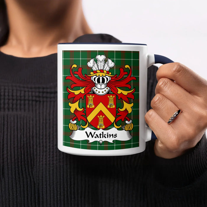 Navy-accent Watkins mug held by its handle, with the red-and-gold shield facing forward.