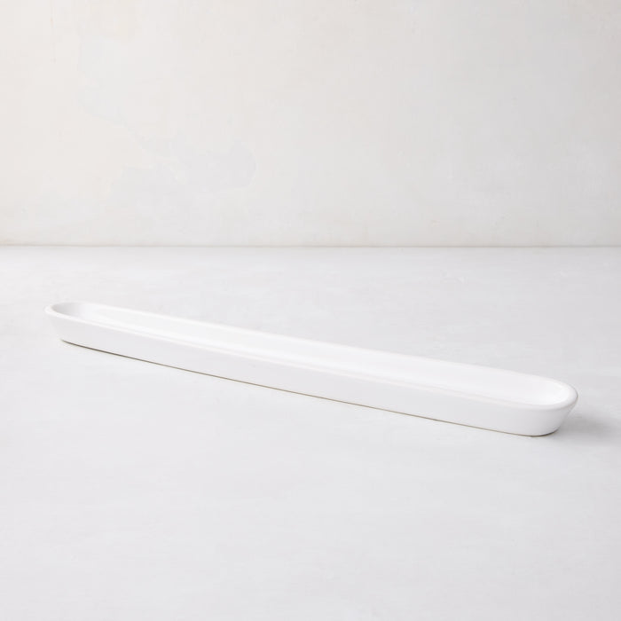 White ceramic olive serving tray, 16" long, with a narrow, rectangular shape and rounded ends.